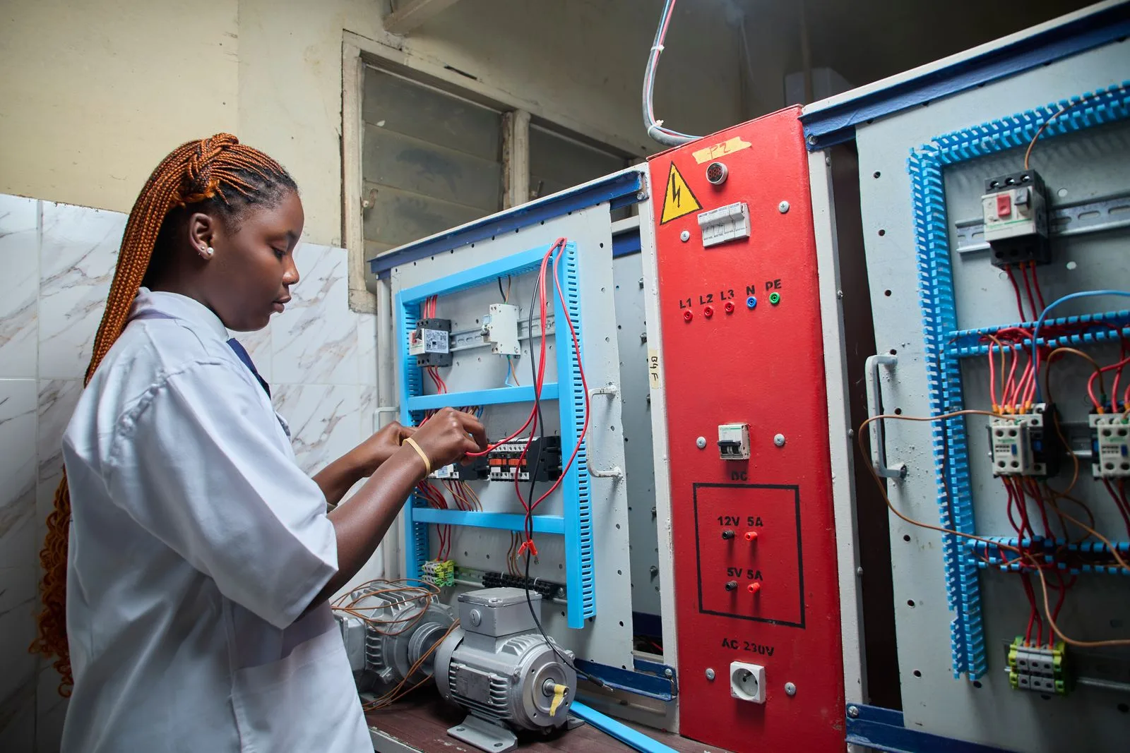 Technicien contrôlant l'armoire électrique d'un système de stockage par batterie en entreprise